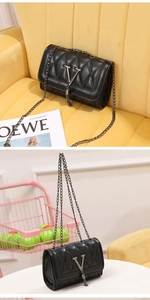 Close-up of black quilted small square bag with silver V-logo and fringe tassel detail