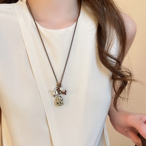 Detailed view of handmade stone and wood beaded pendant on a brown wax cord ethnic necklace