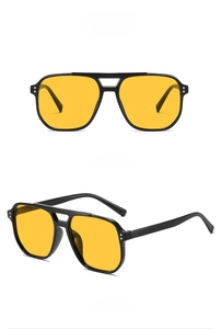 Détail de lunettes de soleil vintage à double pont avec monture noire et verres jaunes
