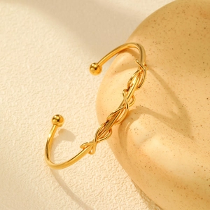 Minimalist gold stainless steel open bangle with woven knot design and ball ends