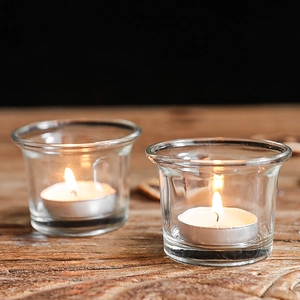 Minimalist transparent glass tealight candle holders on vintage wood tabletop