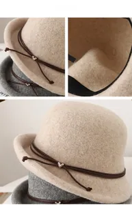 Detail of wool cloche hat showing heart metal buckle, leather rope and soft felt texture