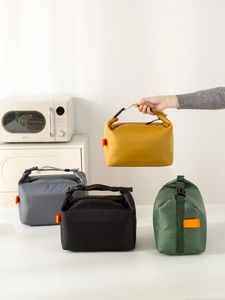 Macro detail of foldable insulated lunch bags in yellow, grey, black, and green colors
