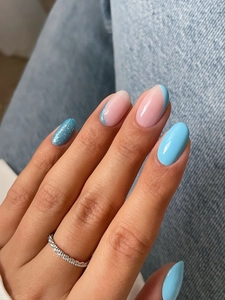 Detailed view of long oval glitter press-on nails in blue and pink with a sparkling ring