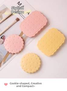 Detailed close-up of pink and yellow biscuit shaped folding mirrors with a comb