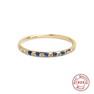Macro detail of gold plated 925 silver ring featuring blue gemstones and white zircons