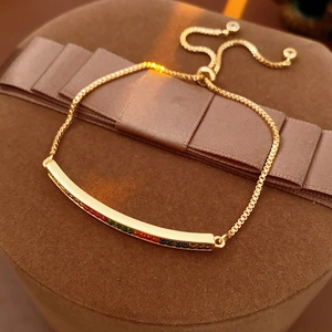 Detail of adjustable gold slider bracelet with vibrant multi-colored inlaid gemstones