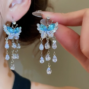 Detail of blue and white zircon butterfly tassel earrings with teardrop crystal pendants