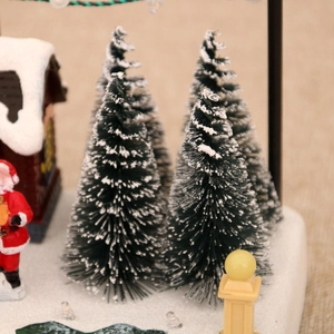 Detailed close-up of a Christmas resin village scene with snowy trees and Santa Claus
