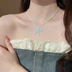 Detail of light blue starfish pendant beaded necklace on neck for summer beach style