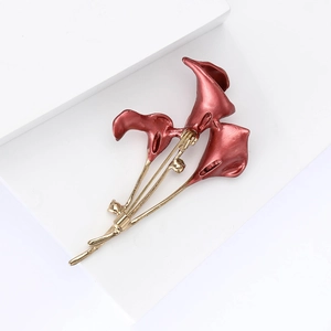 Detail of elegant enamel calla lily brooch with dark red petals and golden metal stem