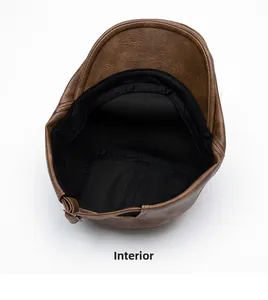 Detail view of brown leather newsboy hat with inner lining and metal buckle