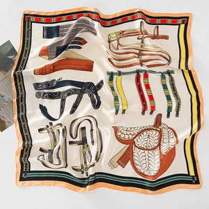 Detailed pattern of a silk-like square scarf featuring equestrian straps and a saddle