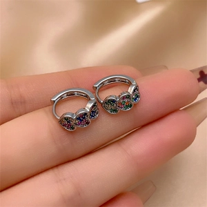 Macro detail of silver hoop earrings featuring colorful heart-shaped cubic zirconia crystals