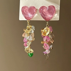Detail of pink heart studs with colorful irregular resin stones on a display card