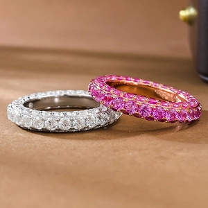 Macro shot of silver and rose gold eternity rings with sparkling pavé stones set in claws