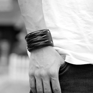 Close-up of black multilayer braided leather punk bracelet with metallic rivet studs
