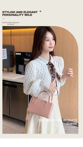 Pink rectangular crossbody bag with fringe tassel detail worn by a model in a white top