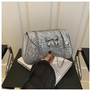 Detailed view of silver sequin evening bag featuring a metallic bow and chain strap