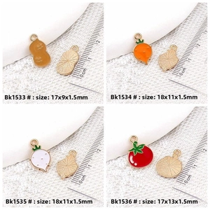 Detail view of colorful enamel vegetable charms with measurements on a scale ruler