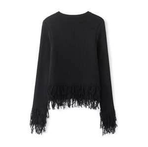 Détail du pull en maille noire avec de longues franges sur l'ourlet et les manches