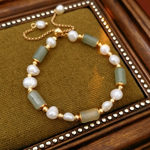 Close-up of pearl and green jade bamboo joint bracelet with gold-plated slider clasp
