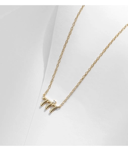 Gros plan du collier doré avec pendentif 777 orné d'un petit diamant étincelant