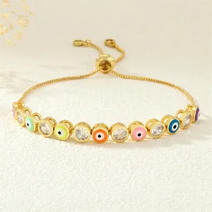 Macro shot of colorful enamel evil eye charms and sparkling zircon on an adjustable gold bracelet