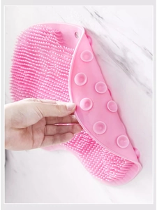 Macro shot of pink silicone bath brush showing dense bristles and suction cup backing