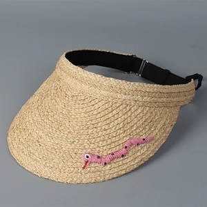 Detailaufnahme der Raffia-Strohkappe mit pinker Schlangenstickerei und verstellbarem Gurt
