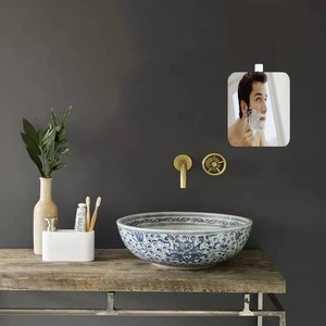 Detail of artistic ceramic countertop basin with blue pattern and gold wall-mounted faucet