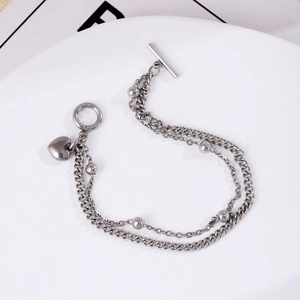 Detail of silver stainless steel double-layer bracelet with heart pendant and toggle clasp
