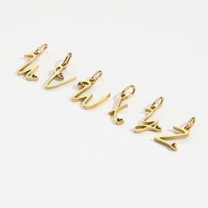 Detailed view of gold letter charms u to z with heart accents for DIY jewelry
