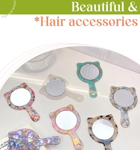 Multiple colorful cat-ear shaped handheld makeup mirrors in various acetate patterns