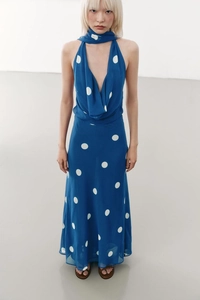 Détail de robe dos nu bleue à pois avec écharpe assortie et décolleté plongeant en V