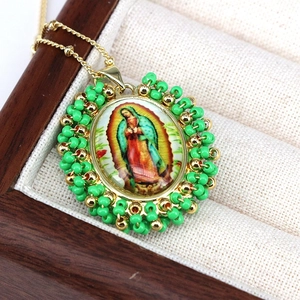 Bohemian Guadalupe pendant necklace with green beads and gold chain on display