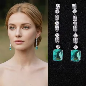 Detail of square emerald pendant earrings with sparkling cubic zirconia on silver setting