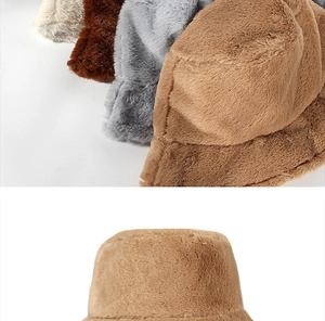 Detail view of plush faux fur bucket hats in beige, brown, and grey soft textures