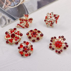 Detailed macro view of vintage gold alloy brooches with red crystals and white rhinestones