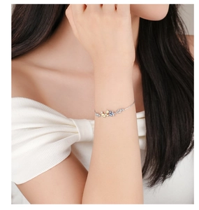 Close-up of S925 silver butterfly bracelet with yellow and blue cubic zirconia on wrist