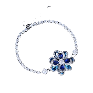 Silver tennis bracelet featuring a blue cubic zirconia flower pendant and adjustable clasp
