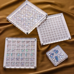 Set of 4 transparent acrylic nail art storage boxes on gold silk fabric background