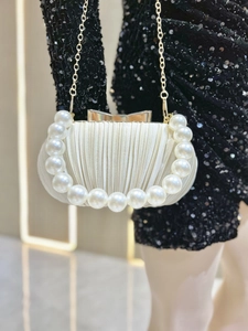 Details einer eleganten Abendtasche aus Satin in Champagner mit Perlen griff und Kette