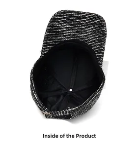 Internal view of black and white tweed baseball cap showing inner lining and metal buckle