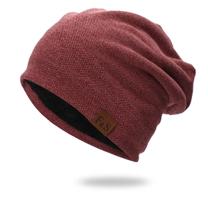 Dettaglio del berretto in maglia rosso scuro con fodera in pile nero e toppa in pelle F&S