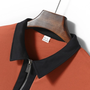 Macro shot of orange polo shirt collar with black zipper and honeycomb mesh texture