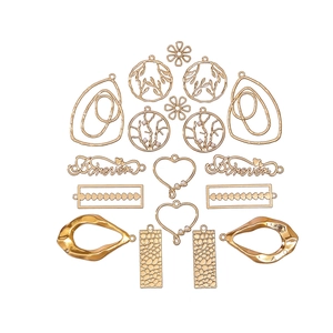 Selection of 18 golden metal DIY jewelry charms in various shapes on a white background