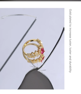 Macro detail of gold-plated ring featuring oval red zircon and sparkling micro-diamonds
