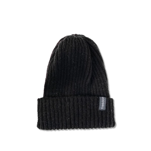 Close-up of the black rib-knit beanie showing the Freedom fabric label detail and texture