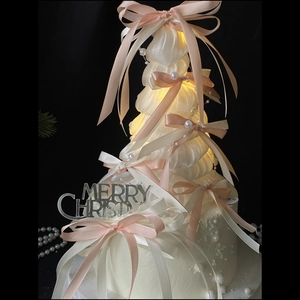 Elegant white ballet-style Christmas tree with pink bows and warm glowing lights